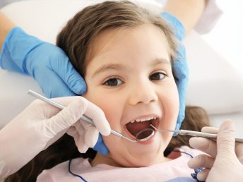 Dentist examining girl's teeth